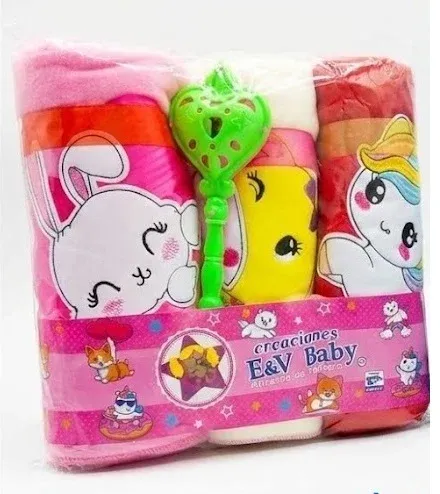 Set de regalo para bebé que incluye cobijas enrolladas en colores rosa, blanco y rojo, junto con una sonaja verde.