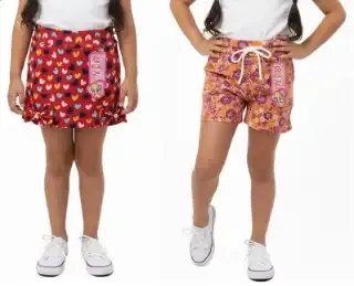 Prendas infantiles: falda short roja con corazones multicolor y short naranja con estampado floral morado.