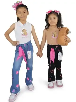 Pantalones de mezclilla azul y negro con bordados de flores y corazones, modelados con playeras de diseño capibara.